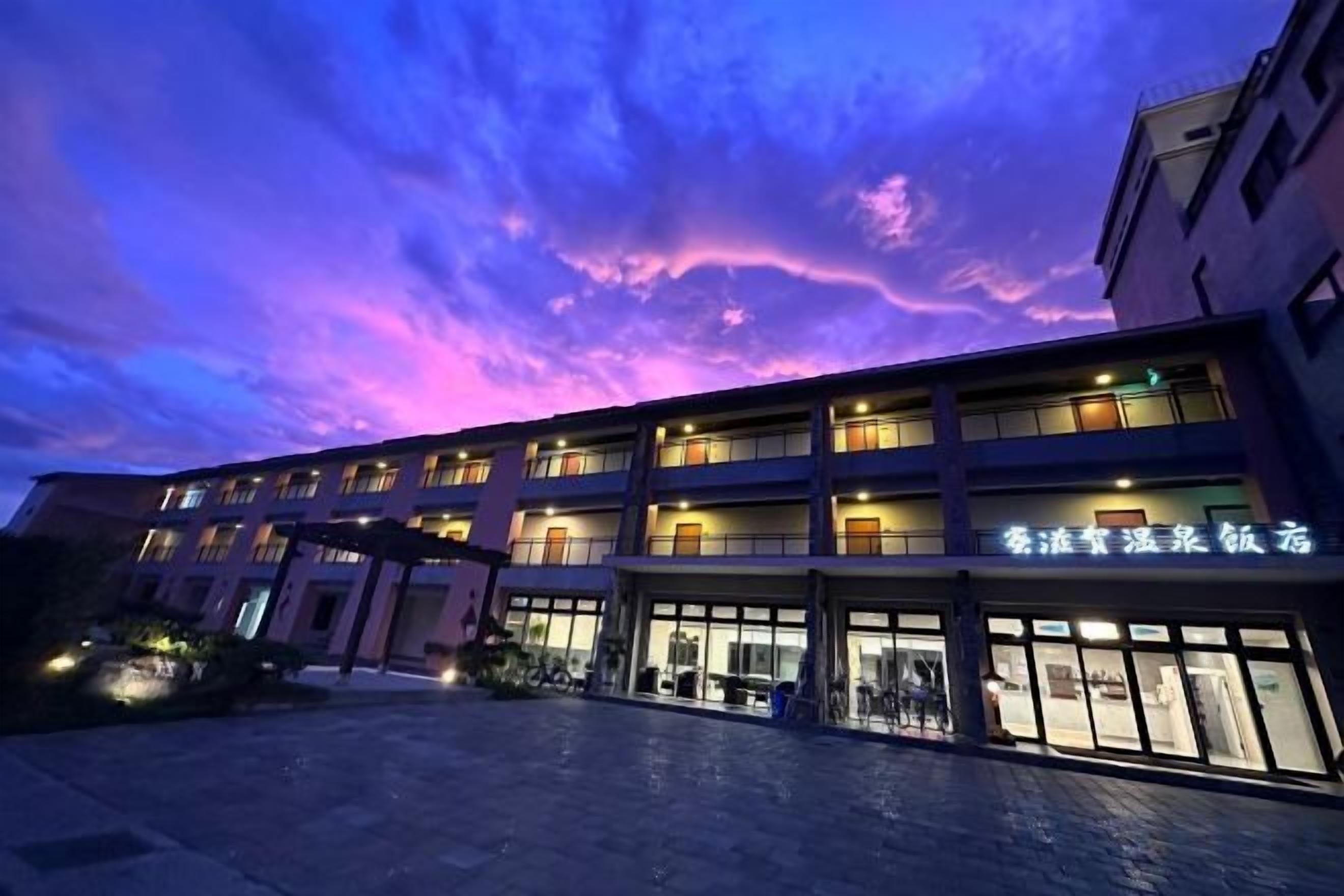 A multi-story hotel with a well-lit entrance and signage.