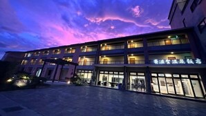 A multi-story hotel with illuminated windows and a sign in a foreign language. - Mizuho Hotel (Hualien)