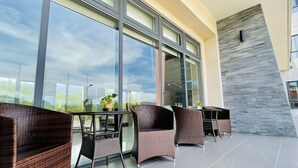 A modern outdoor seating area with wicker furniture and large windows. - Mizuho Hotel (Hualien)