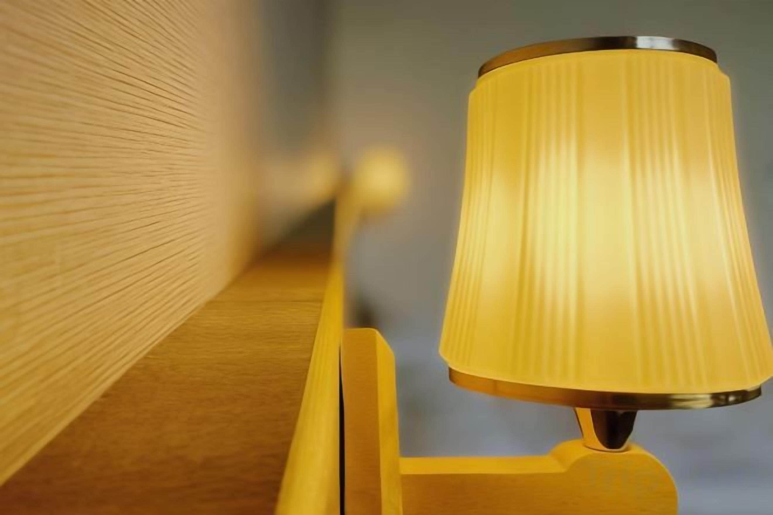 Une lampe dotée d’un abat-jour cylindrique, posée sur une surface en bois.