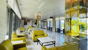 A modern hotel lobby with yellow seating, large windows, and a marble coffee table. - Mizuho Hotel (Hualien)