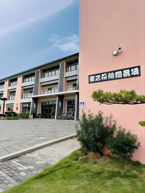 A multi-story building with a modern architectural design, featuring a prominent entrance with a glass facade and a signboard. - Mizuho Hotel (Hualien)