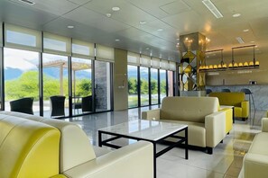 A hotel lobby with a seating area, large windows, and a reception desk. - Mizuho Hotel (Hualien)