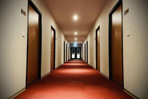 A long, narrow hallway with doors on both sides, leading to a bright end. - Mizuho Hotel (Hualien)