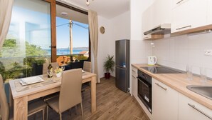 Eine moderne Küche mit Essbereich, großen Fenstern und Meerblick.