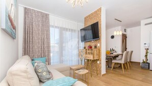 A modern living room with a sofa, TV, and dining area. - Villa LA-Two Bedroom Apartment with Terrace (Drvenik Veliki)