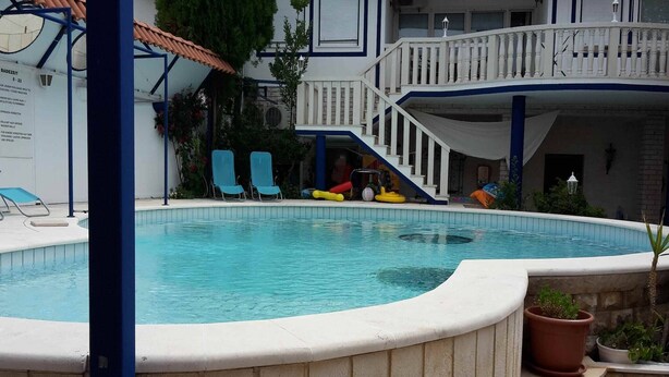 A swimming pool with a white deck, blue chairs, and a small slide. - Villa Elit-Two Bedroom Apartment with  Sea View Terrace ( A1) (Sumpetar)