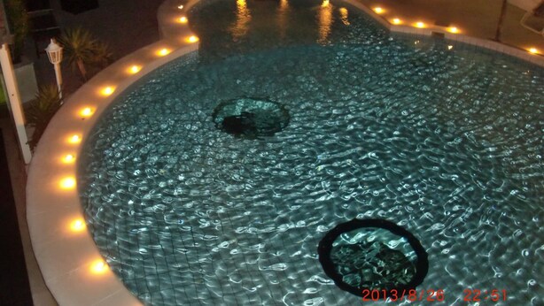 A hot tub with a circular shape, surrounded by a tiled edge and illuminated by small lights. - 2 bedroom apartment with terrace (Sumpetar)