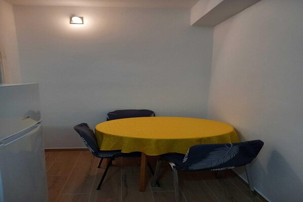 A small dining area with a yellow table and four chairs. - Apartments Kalajzic - Two Bedroom Apartment with Garden and Terrace(A2) (ST) (Pucisca)