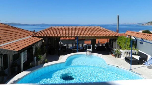 A swimming pool with a view of the sea, a covered patio area, and a clear blue sky. - Villa Elit- Three Bedroom Apartment with Sea View Terrace (Penthouse) (Sumpetar)
