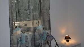 A room with a chair and a table, a lamp on the table, and a wall with a bicycle pattern. - Villa Elit - Comfort Two Bedroom Apartment with Terrace ( A5) (Sumpetar)