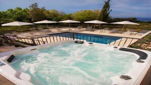 A hot tub with a view of the ocean, surrounded by lounge chairs and umbrellas. - Apartments Villa Lukas - ''No.3'' Studio Apartment with Balcony and Sea View (Cavtat)