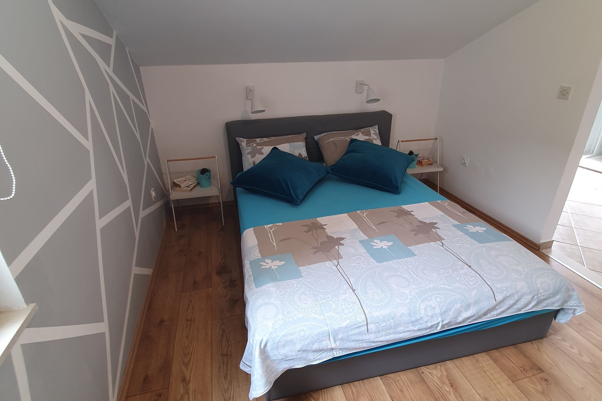 Una camera da letto con un letto, due comodini e un tavolino da notte.