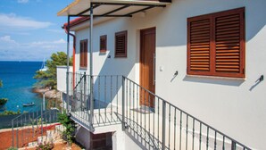 A coastal building with a balcony, wooden shutters, and a view of the sea. - Hedonistic villa and a unique view from the terrace that changes 24 hours a day (Jelsa)
