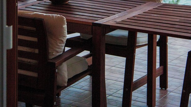 A wooden table with a bowl of lemons, two cushioned chairs, and a view of a lake with boats and trees. - Hedonistic villa and a unique view from the terrace that changes 24 hours a day (Jelsa)