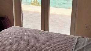 A room with a bed and a view of a body of water through a sliding door. - Hedonistic villa and a unique view from the terrace that changes 24 hours a day (Jelsa)