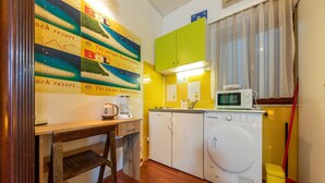 Una cocina compacta equipada con lavadora, microondas y cafetera.