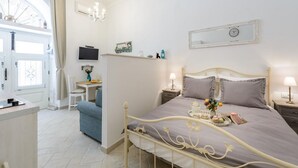 Un dormitorio con cama, mesitas de noche, televisor, escritorio y silla.