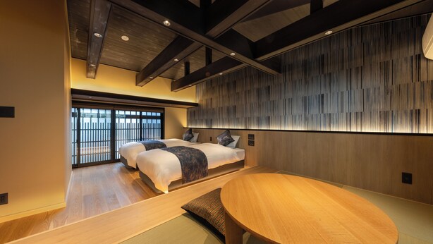A modern hotel room with two beds, a wooden dining table, tatami mats, and a large window with a view. - Kanade GionRokuhara (Kyoto)