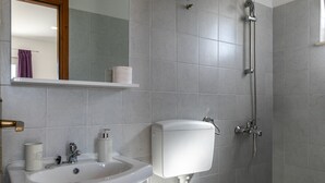 Un bany amb rentamics, vàter i plat de dutxa.