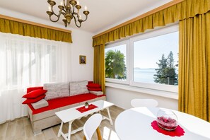 Una sala de estar moderna con un sofá, una mesa y vistas al mar.