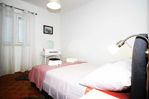 Une chambre à coucher avec un lit, une table de chevet, un miroir et une lampe.