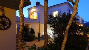 A building with a staircase, a wheel, and a well-lit entrance. - Apartment Marita - One Bedroom Apartment with Balcony (Cilipi)