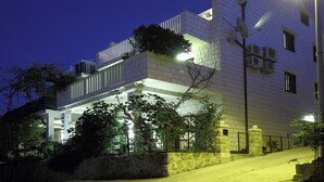 Un edificio moderno con balcón, antena parabólica y unidades de aire acondicionado.