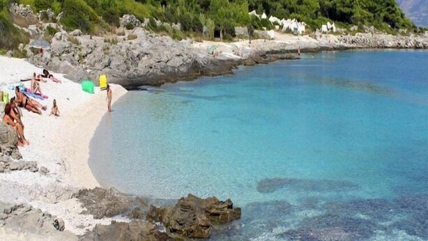 A beach with clear blue water, rocky shoreline, and white sand. - Apartment OM - One Bedroom Apartment with Balcony and Sea view (Povlja)