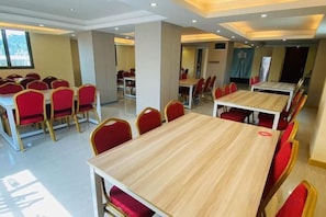 A conference room with multiple tables and chairs, arranged in rows. - Liansheng Hotel (Fuding Taiyushan Branch) (Fuding)