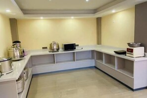 A kitchen with a white countertop, stainless steel appliances, and a tiled floor. - Liansheng Hotel (Fuding Taiyushan Branch) (Fuding)
