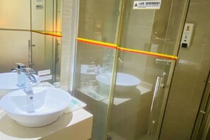 A modern bathroom with two sinks, a glass shower enclosure, and a visible safety sign. - Liansheng Hotel (Fuding Taiyushan Branch) (Fuding)