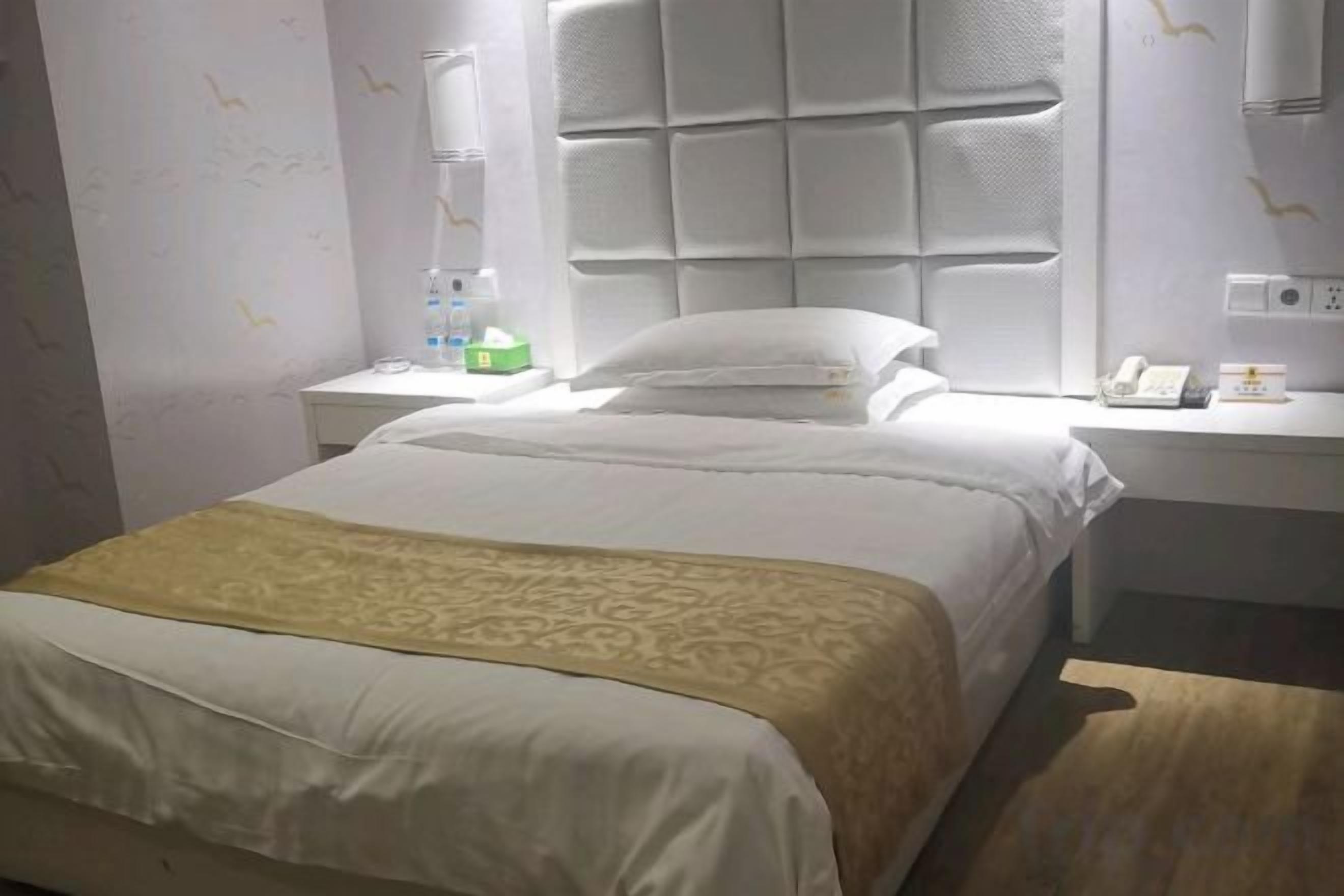 Ett hotellrum med en säng, ett nattduksbord och ett fönster med utsikt.