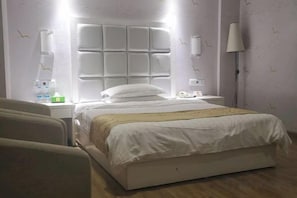 A hotel room with a large bed, a bedside table, a lamp, and a chair. - Liansheng Hotel (Fuding Taiyushan Branch) (Fuding)