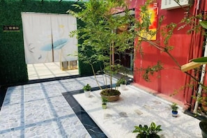A courtyard with a patterned floor, potted plants, and a red wall. - Liansheng Hotel (Fuding Taiyushan Branch) (Fuding)