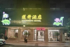 A hotel with a prominent neon sign, a round entrance, and a visible entrance door. - Liansheng Hotel (Fuding Taiyushan Branch) (Fuding)