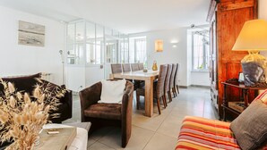 Un salon moderne avec un canapé, une table à manger et des chaises, une lampe et un grand miroir.