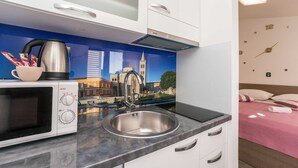 A modern kitchen with a microwave, kettle, and sink.