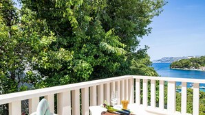 A balcony with a table set for a meal, overlooking a scenic coastal view. - Apartments & Rooms Mara & Petrunjela - One Bedroom Apartment with Balcony and Sea View (Cavtat)