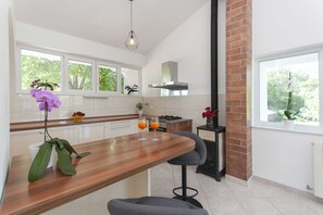 Eine moderne Küche mit einer Holztheke, einem Gasherd und einer Ziegelwand.