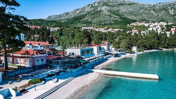 A coastal hotel with a beach view, a pier, and a mountainous backdrop. - Apartments Grljević - Studio Apartment with Sea View and Balcony (A2) (Mlini)