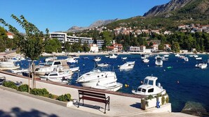A marina with numerous boats docked, a bench, and buildings in the background. - Apartments Grljević - Studio Apartment with Sea View and Balcony (A2) (Mlini)