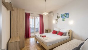 Un dormitorio con cama, armario de madera, puerta de vidrio corredera y una lámpara en el techo.