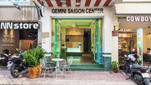 Een winkelgevel met een bord voor 'Gemini Saigon Center' en een restaurant 'Cowboy'.
