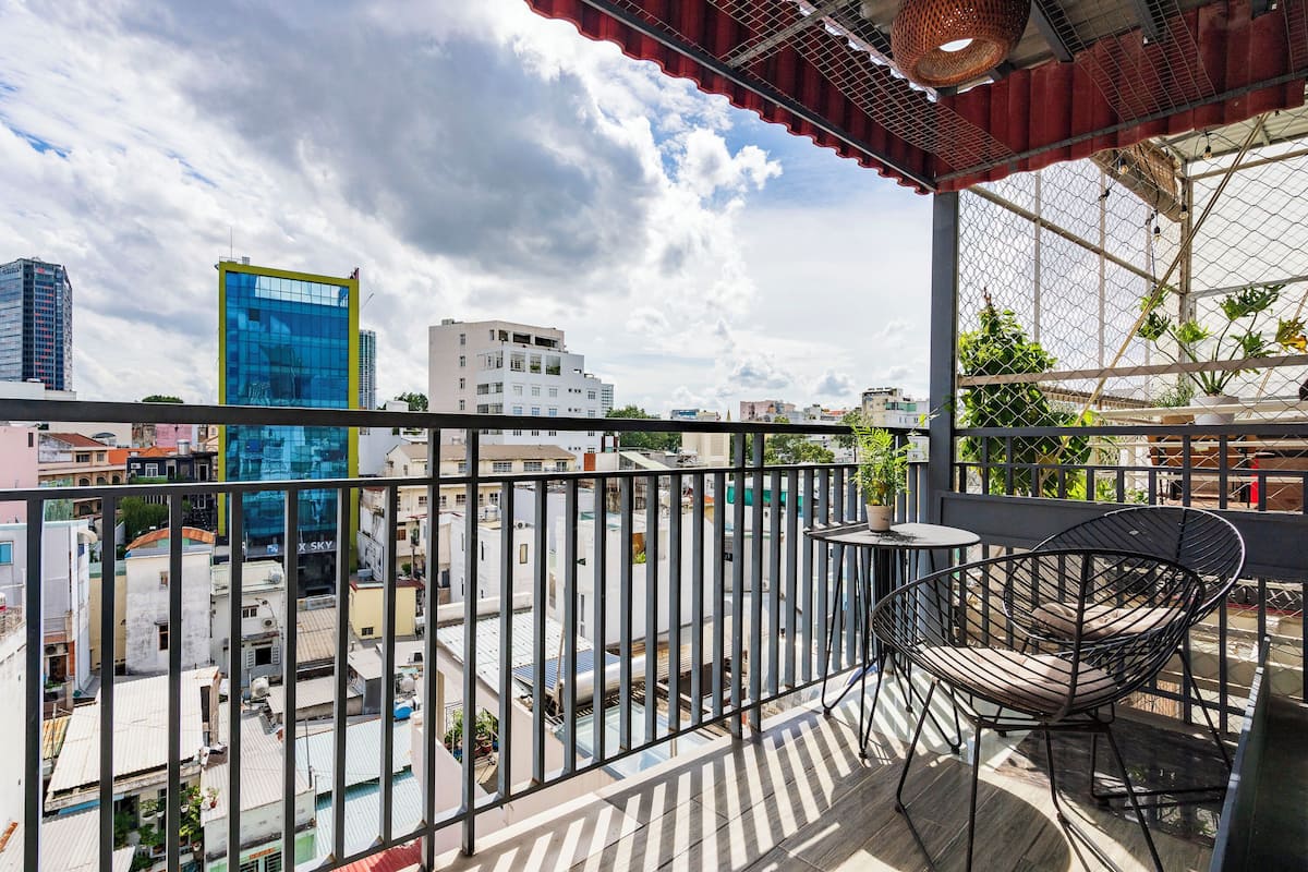 Un balcon avec une balustrade en métal, une chaise et une petite table.