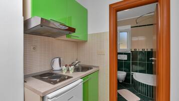 Coffee/tea maker, fridge, stovetop, dining tables
