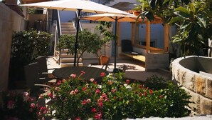 A courtyard with outdoor seating, a pergola, and potted plants.