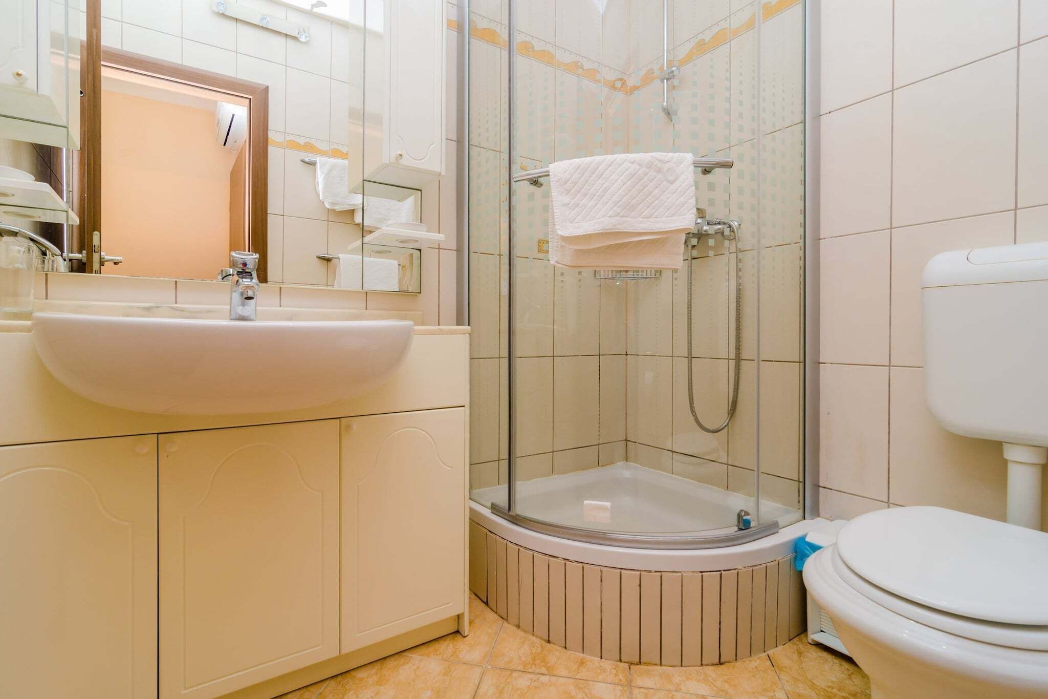 A bathroom with a sink, toilet, and glass-enclosed shower.