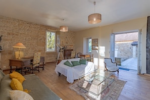 A bedroom with a bed, a desk, a chair, a lamp, and a view of the outside.