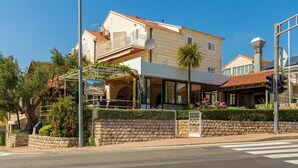 Un hotel con fachada de piedra, un balcón y una entrada moderna.